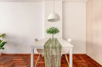 a dining room with a white table and a vase with flowers at Departamentos Lugar in Cordoba