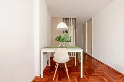 a white dining room table with a white chair at Departamentos Lugar in Cordoba
