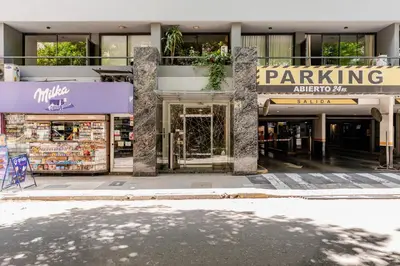 a building with a parking sign in front of a store at Departamentos Lugar in Cordoba