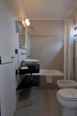 a bathroom with a sink and a tub and a toilet at Madeo Hotel & Spa in Villa Carlos Paz