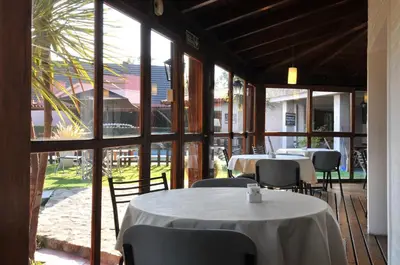 a restaurant with tables and chairs and large windows at Madeo Hotel & Spa in Villa Carlos Paz