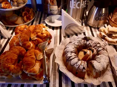 a table topped with plates of pastries and pies at Madeo Hotel & Spa in Villa Carlos Paz