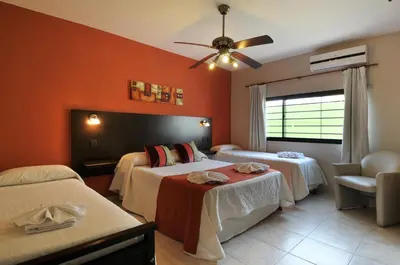 a hotel room with two beds and a ceiling fan at Madeo Hotel & Spa in Villa Carlos Paz