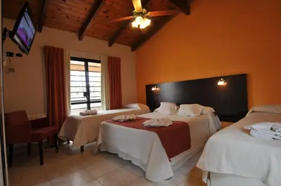 a hotel room with two beds and a tv at Madeo Hotel & Spa in Villa Carlos Paz