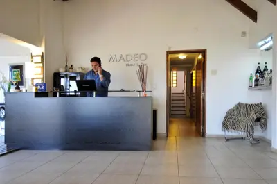 a man talking on a cell phone behind a counter at Madeo Hotel & Spa in Villa Carlos Paz