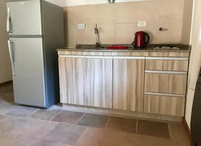 a kitchen with a white refrigerator and wooden cabinets at Cabañas Landhaus in Villa General Belgrano
