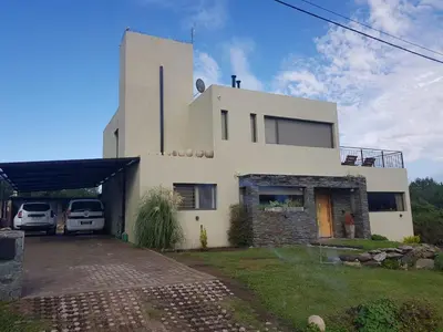 a white house with cars parked in front of it at MIracampo in San Antonio de Arredondo