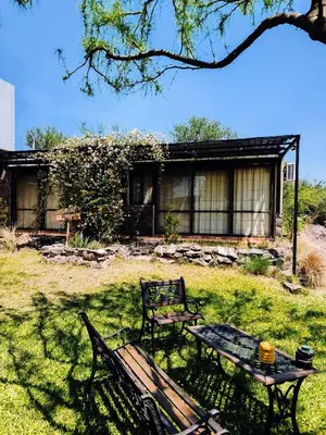 a table and a bench in front of a house at MIracampo in San Antonio de Arredondo