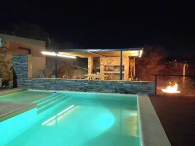 a swimming pool at night with a fire place at MIracampo in San Antonio de Arredondo