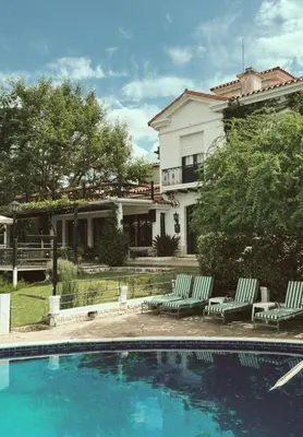 a house with a swimming pool in front of a house at Juliette Posada Boutique Ex Posada La Villa in Villa Carlos Paz