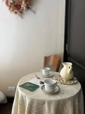 a table with two cups and a vase on it at Juliette Posada Boutique Ex Posada La Villa in Villa Carlos Paz