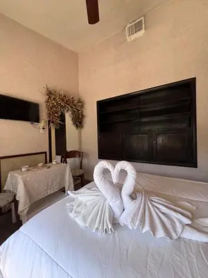a towel heart sitting on top of a bed at Juliette Posada Boutique Ex Posada La Villa in Villa Carlos Paz