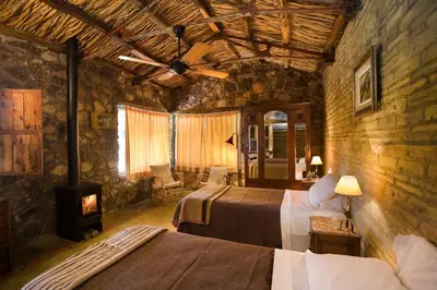 a bedroom with two beds and a ceiling fan at LAS JARILLAS Hostería & Bodega in San Javier