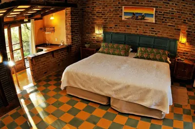 a bedroom with a large bed in a brick wall at LAS JARILLAS Hostería & Bodega in San Javier
