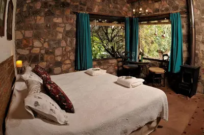 a bedroom with a bed with pillows and a window at LAS JARILLAS Hostería & Bodega in San Javier