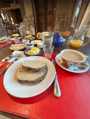 a table with a plate of food on a red table at LAS JARILLAS Hostería & Bodega in San Javier