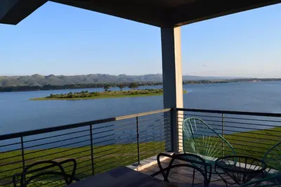 a balcony with chairs and a view of a lake at Puerto del Águila Departamentos sobre el Lago - The View Luxury Aparts in Potrero de Garay