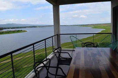 a balcony with a table and chairs and a view of a lake at Puerto del Águila Departamentos sobre el Lago - The View Luxury Aparts in Potrero de Garay