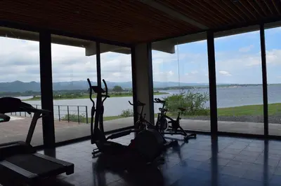 a gym with three exercise bikes in front of a window at Puerto del Águila Departamentos sobre el Lago - The View Luxury Aparts in Potrero de Garay