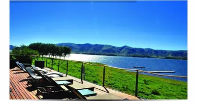 a group of tables and chairs next to a lake at Puerto del Águila Departamentos sobre el Lago - The View Luxury Aparts in Potrero de Garay