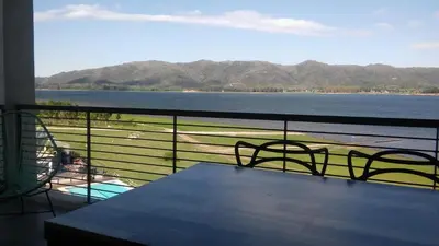 a balcony with a table and chairs and a view of the water at Puerto del Águila Departamentos sobre el Lago - The View Luxury Aparts in Potrero de Garay