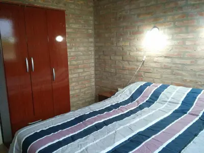 a bedroom with a bed and a brick wall at El Retiro - Casa de campo en Los Reartes in Los Reartes
