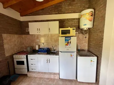 a kitchen with a refrigerator and a microwave at El Retiro - Casa de campo en Los Reartes in Los Reartes