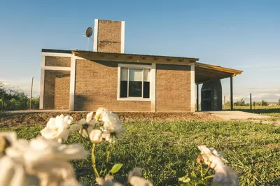 a house with flowers in front of it at El Retiro - Casa de campo en Los Reartes in Los Reartes