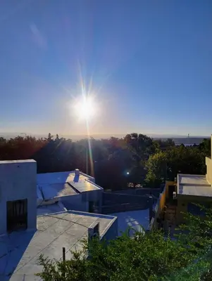 a view of the sun setting over a house at Casa en Barrio Costa Azul in Villa Carlos Paz