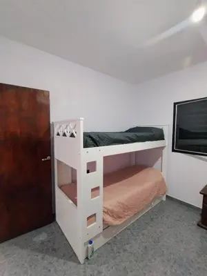 a white bunk bed in a room with a door at Casa en Barrio Costa Azul in Villa Carlos Paz
