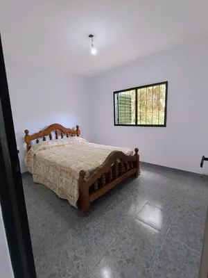 a bedroom with a bed in a white room at Casa en Barrio Costa Azul in Villa Carlos Paz