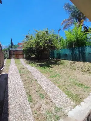 a path in a yard with a fence and trees at Casa en Barrio Costa Azul in Villa Carlos Paz