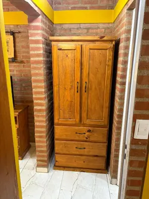 a wooden cabinet in the corner of a room at La bendicion in Villa Cura Brochero