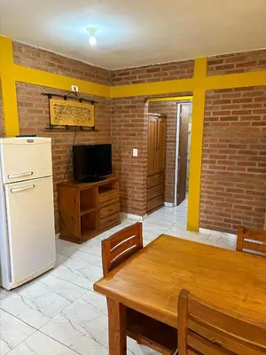 a kitchen with a wooden table and a refrigerator at La bendicion in Villa Cura Brochero