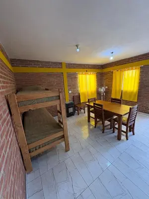 a room with tables and chairs and yellow curtains at La bendicion in Villa Cura Brochero