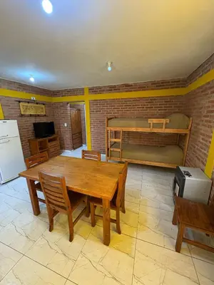 a kitchen with a wooden table and a bunk bed at La bendicion in Villa Cura Brochero