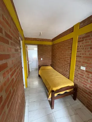 a bedroom with a bed in a brick wall at La bendicion in Villa Cura Brochero