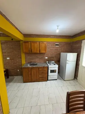 a kitchen with a white stove and a refrigerator at La bendicion in Villa Cura Brochero
