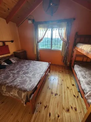 a bedroom with two bunk beds and a window at Cabañas Dulce Atardecer in Villa Carlos Paz
