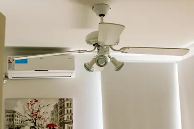 a ceiling fan in a room with a air conditioner at Departamentos Córdoba Holder II in Cordoba