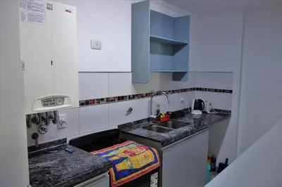 a small white kitchen with a sink and a counter at Departamentos Córdoba Holder II in Cordoba
