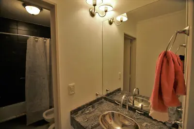 a bathroom with a sink and a large mirror at Departamentos Córdoba Holder II in Cordoba