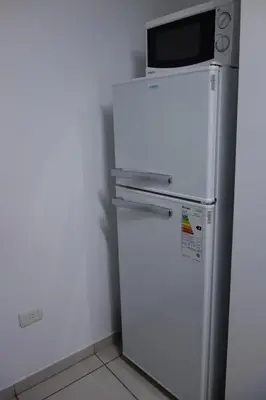 a white refrigerator with a microwave on top of it at Departamentos Córdoba Holder II in Cordoba