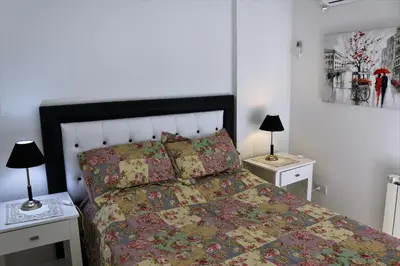 a bedroom with a bed and two night stands with lamps at Departamentos Córdoba Holder II in Cordoba
