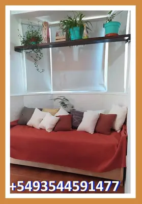 a red couch with pillows on it in a room at La casita de Chany in Mina Clavero