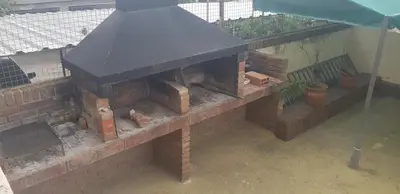 an outdoor brick fireplace with a black roof at 76 Arruabarrena in Villa Carlos Paz