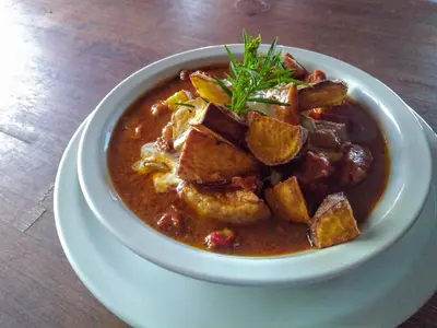 a bowl of soup on a plate on a table at Posada Las Vertientes in Copina
