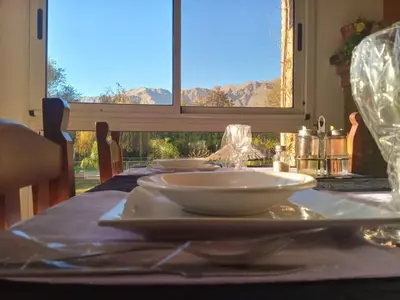 a table with white dishes on a table with a window at Hotel Terrazas del Rincon in Merlo
