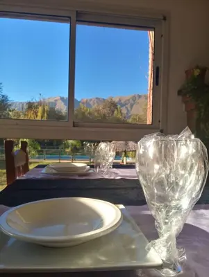 a table with a plate and two glass vases on it at Hotel Terrazas del Rincon in Merlo