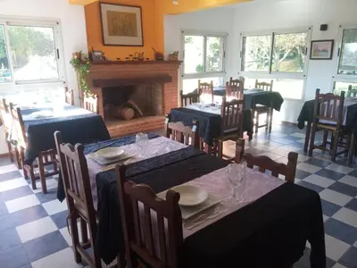a dining room with tables and chairs and a fireplace at Hotel Terrazas del Rincon in Merlo